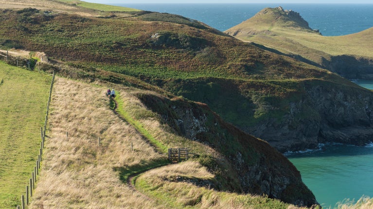 Visitors walking the coast path at Pentire headland, Cornwall